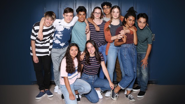 Les ados posent contre les casiers du collège. Ils sourient. Les ados posent contre les casiers du collège. Ils sourient.