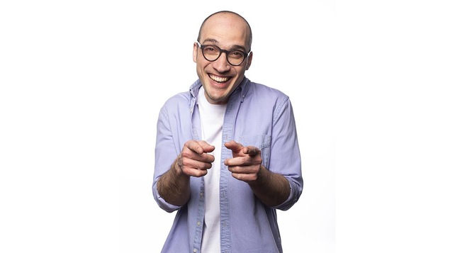 Homme souriant, portant des lunettes et une chemise à manche slongues