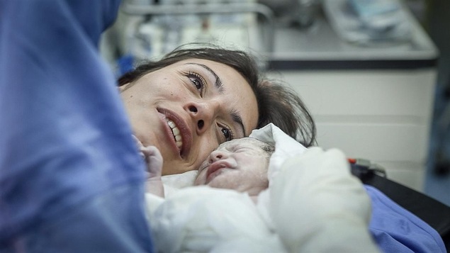 Une femme regarde son bébé quelques instants après l'accouchement.