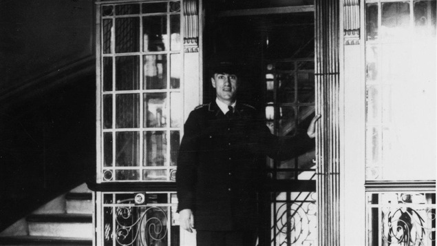 En 1930, un garçon d'ascenseur attend des passagers.