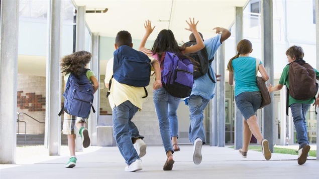 Une groupe d'enfants sort de l'école.