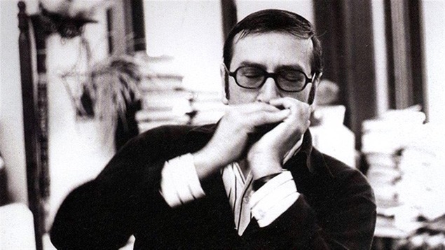 Gaston Miron jouant de l'harmonica.