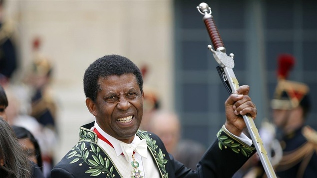 Dany Laferrière tenant son épée d'apparat de l'Académie française
