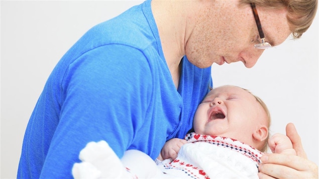 Un père regarde son bébé souffrir.