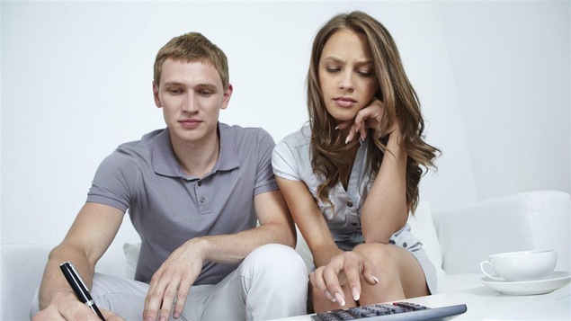Un couple calcule ses dépenses.