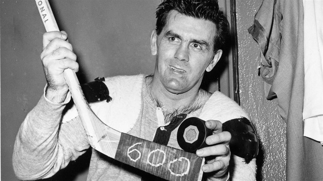 Maurice Richard montre la rondelle du 600e but de sa carrière dans la Ligue nationale, en comptant ceux marqués pendant les séries.