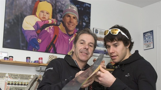 Pierre et Alex Harvey devant un poster les représentant tous deux 20 ans plus tôt