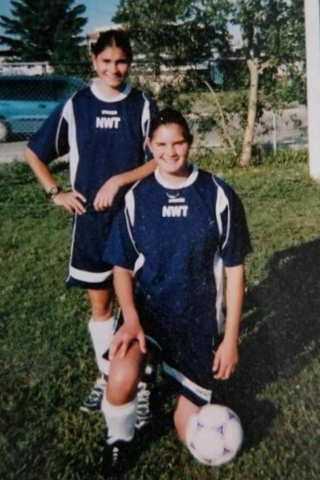 Deux jeunes filles posent sur un terrain de soccer. Deux jeunes filles posent sur un terrain de soccer.