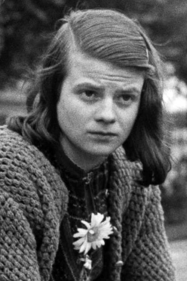 Photo en noir et blanc d'une jeune femme portant une fleur sur son vêtement. Photo en noir et blanc d'une jeune femme portant une fleur sur son vêtement.