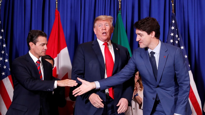 Justin Trudeau et Enrique Pena Nieto se serrent la main tandis que Donald Trump les regarde, lors de la cérémonie de signature de l'AUEMC, avant la rencontre des leaders du G20 à Buenos Aires, en Argentine, le 30 novembre 2018.