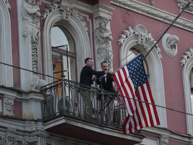 Des employés du consulat des États-Unis à Saint-Petersbourg descendent le drapeau américain de la façade de la bâtisse le 31 mars 2018.