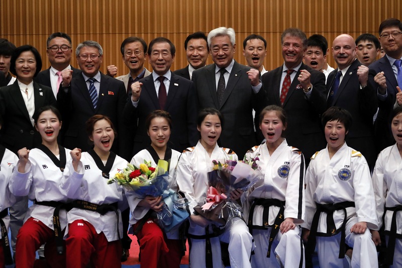Des membres des équipes nord-coréenne et sud-coréenne posent après avoir participé à une performance de taekwondo conjointe à Séoul, le 12 février 2018, en marge des Jeux olympiques d'hiver de Pyeongchang.