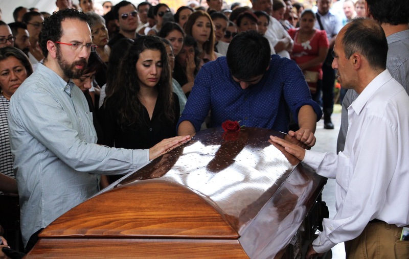 Les proches endeuillés du journaliste assassiné Juan Carlos Huerta se penchent sur son cercueil durant ses funérailles au cimetière de Villahermosa, dans l'État deTabasco le 16 mai 2018.