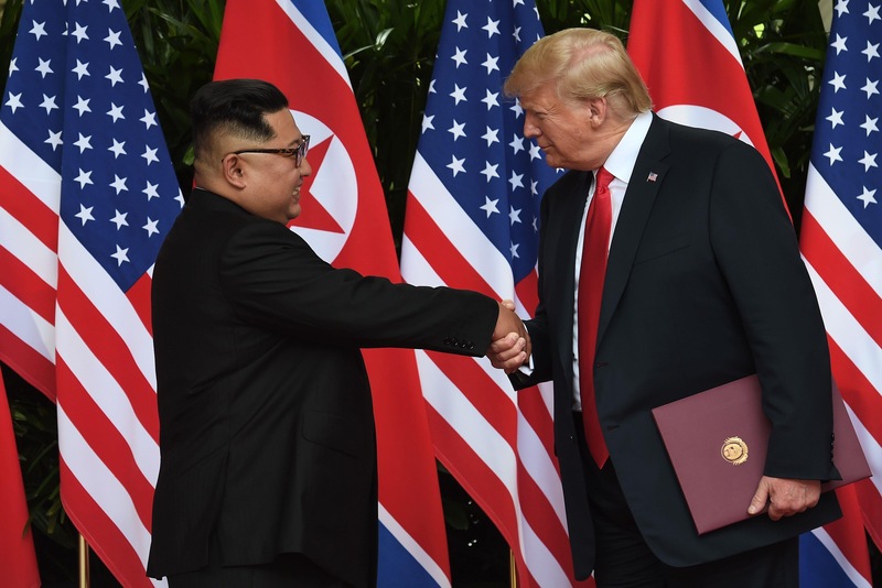 Kim Jong-un serre la main à Donald Trump après avoir pris part à une cérémonie de signature à la fin de leur sommet, à l'hôtel Capella sur l'île de Sentosa, à Singapour, le 12 juin 2018.