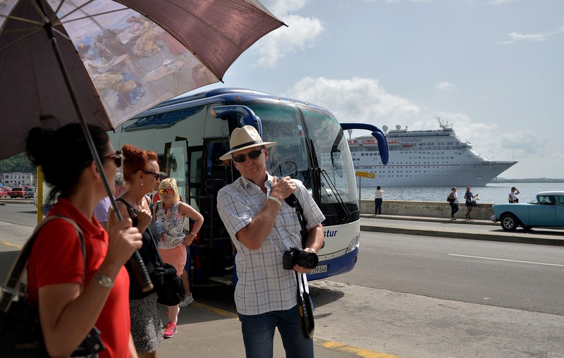 Des touristes descendent d'un autocar nolisé devant un bateau de croisière à La Havane, le 10 août 2018.