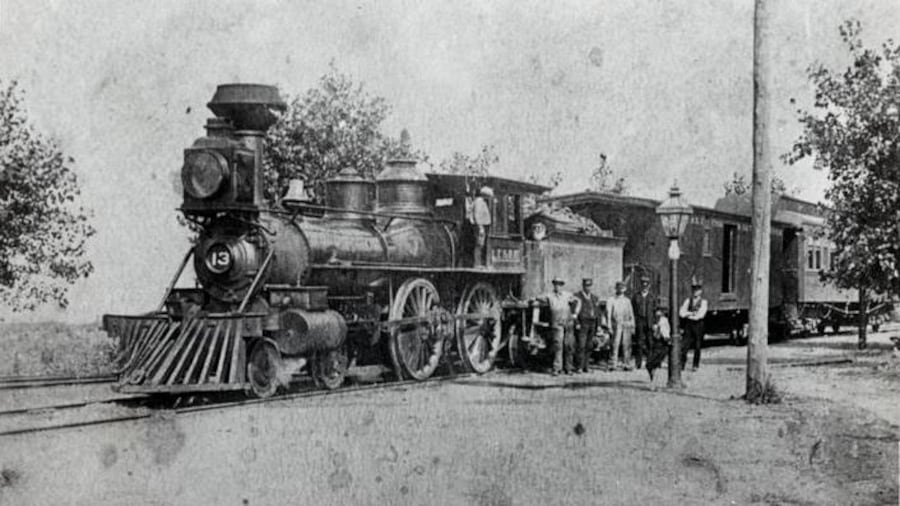 Photo du train à l'arrêt avec des personnes à côté de la locomotive. Photo du train à l'arrêt avec des personnes à côté de la locomotive.