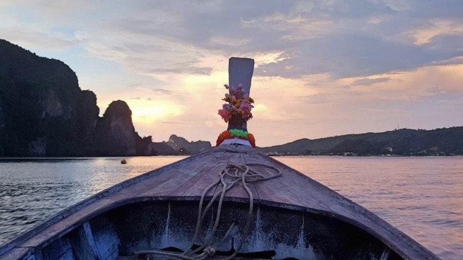 La coque d'un bateau sur la baie Maya, en Thaïlande, et un coucher de soleil La coque d'un bateau sur la baie Maya, en Thaïlande, et un coucher de soleil