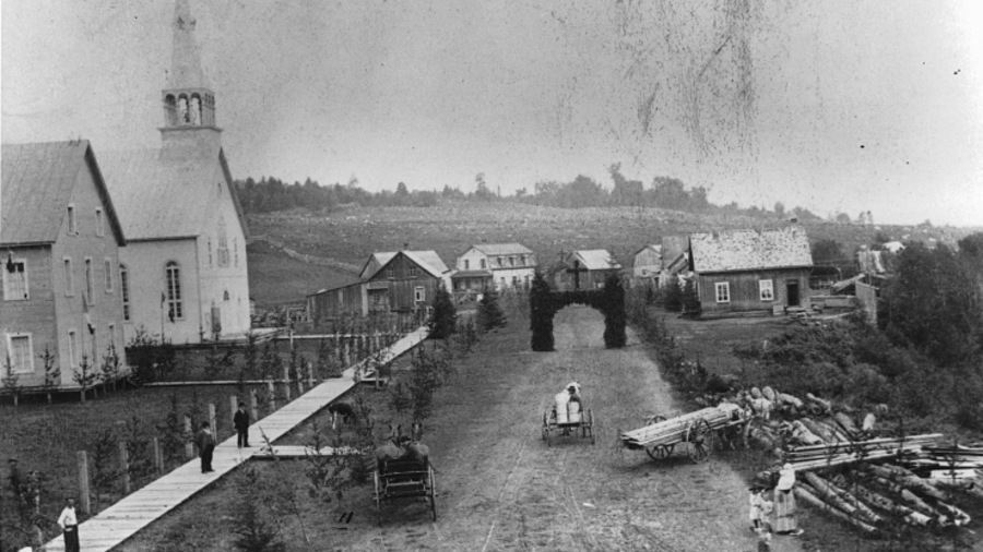 Une photographie en noir et blanc montrant la rue principale du petit village de L'Annonciation, au moment de la colonisation des Laurentides Une photographie en noir et blanc montrant la rue principale du petit village de L'Annonciation, au moment de la colonisation des Laurentides