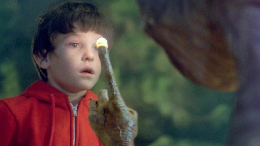 E.T. l'extra-terrestre lève le doigt en montrant le ciel devant Elliot (Henry Thomas). E.T. l'extra-terrestre lève le doigt en montrant le ciel devant Elliot (Henry Thomas).
