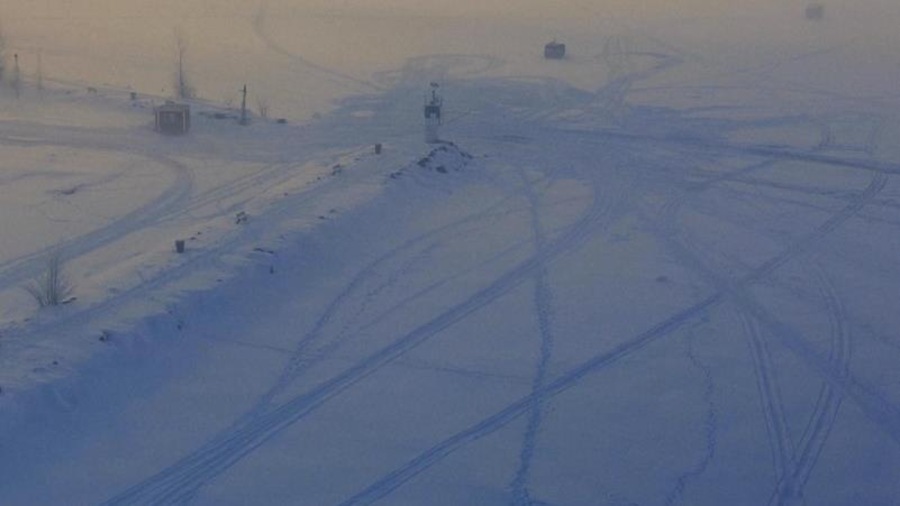 Une vue aérienne d'un champ de neige, traversé de quelques lignes.