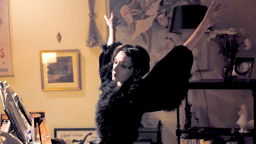 Une femme habillée en noir, assise devant un piano, les bras en l'air. Une femme habillée en noir, assise devant un piano, les bras en l'air.