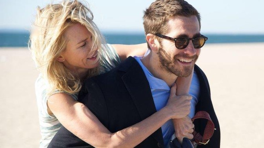 Une femme (Naomi Watts) sur le dos d'un homme (Jake Gyllenhaal) sur une plage.