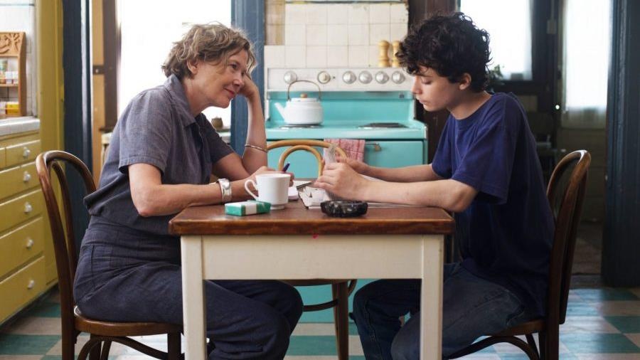Une femme et un jeune homme se font face autour d'une table de cuisine. Une femme et un jeune homme se font face autour d'une table de cuisine.