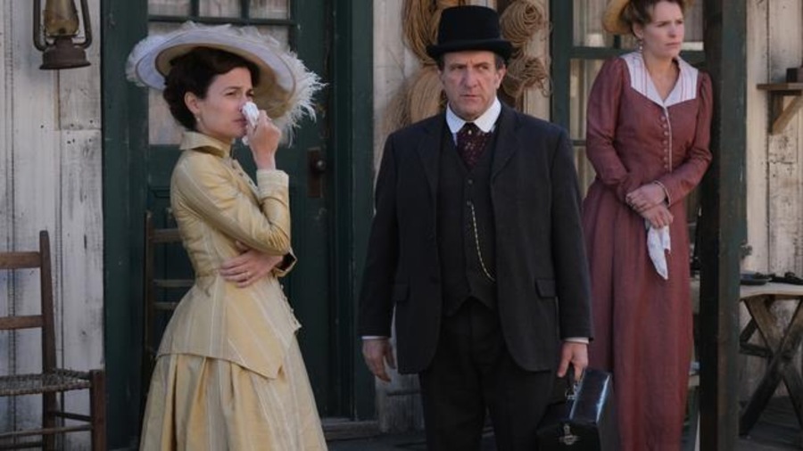 Les deux femmes et l'homme, habillés de vêtements d'époque, regardent au loin et semblent tristes. Les deux femmes et l'homme, habillés de vêtements d'époque, regardent au loin et semblent tristes.