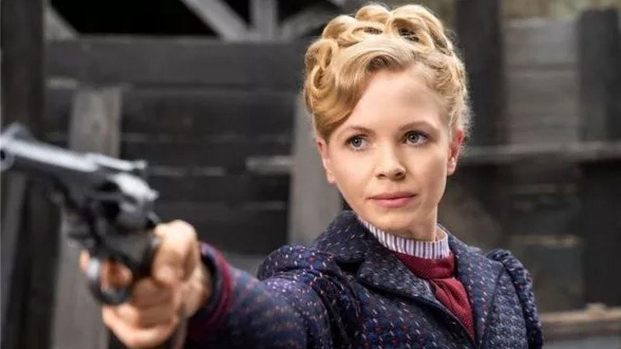 Une jeune femme tient un revolver.