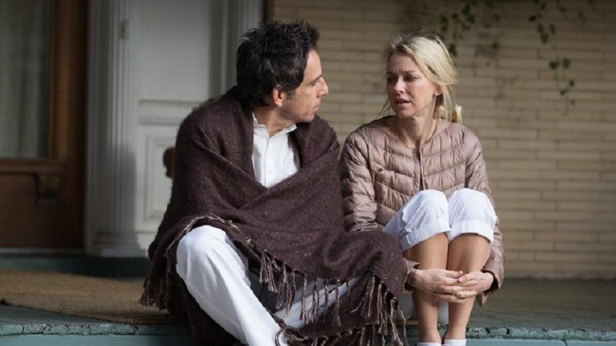 Un homme avec une couverture sur les épaules et une femme avec un manteau assis sur des marches extérieures devant une maison. Un homme avec une couverture sur les épaules et une femme avec un manteau assis sur des marches extérieures devant une maison.