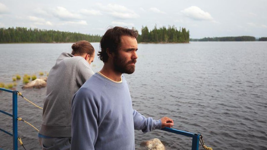 Deux jeunes hommes, sur un quai, regardent le lac. Deux jeunes hommes, sur un quai, regardent le lac.