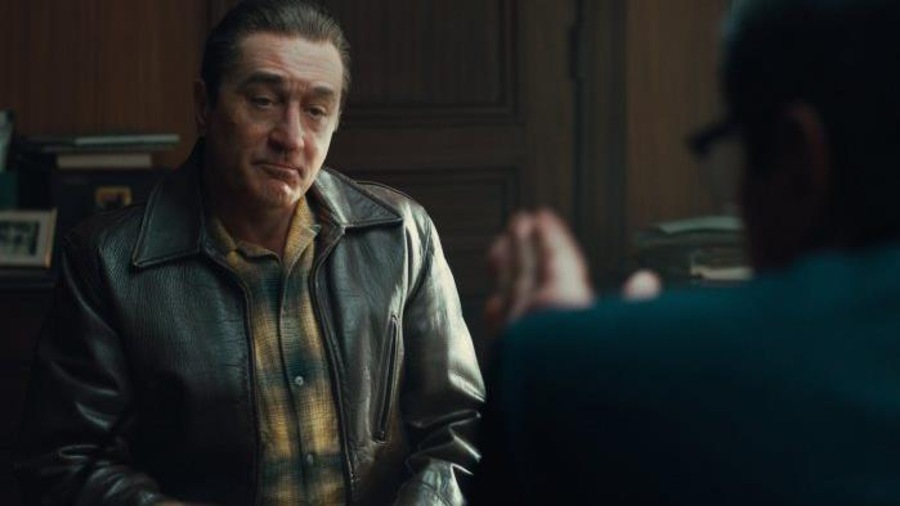 Un homme (Robert DeNiro) en blouson de cuir, assis dans un bureau, écoute un autre homme de dos. Un homme (Robert DeNiro) en blouson de cuir, assis dans un bureau, écoute un autre homme de dos.