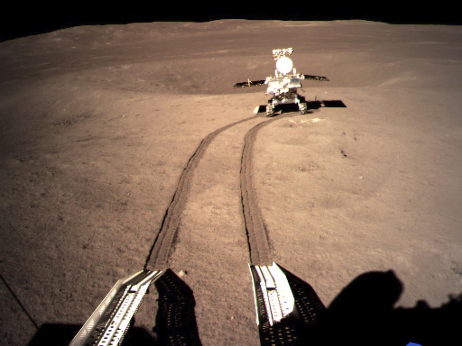 Photo d'un robot posé sur la Lune avec des traces de roues. Photo d'un robot posé sur la Lune avec des traces de roues.