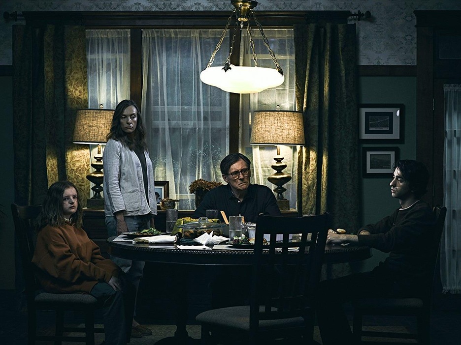 Deux enfants et un homme sont assis à une table ronde pendant qu'une femme se tient debout. Deux enfants et un homme sont assis à une table ronde pendant qu'une femme se tient debout.