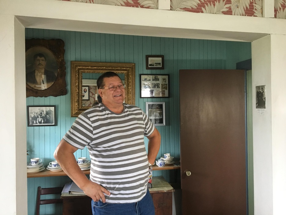 Un homme pose les mains sur les hanches, souriant, dans une maison au décor d'antan. Un homme pose les mains sur les hanches, souriant, dans une maison au décor d'antan.