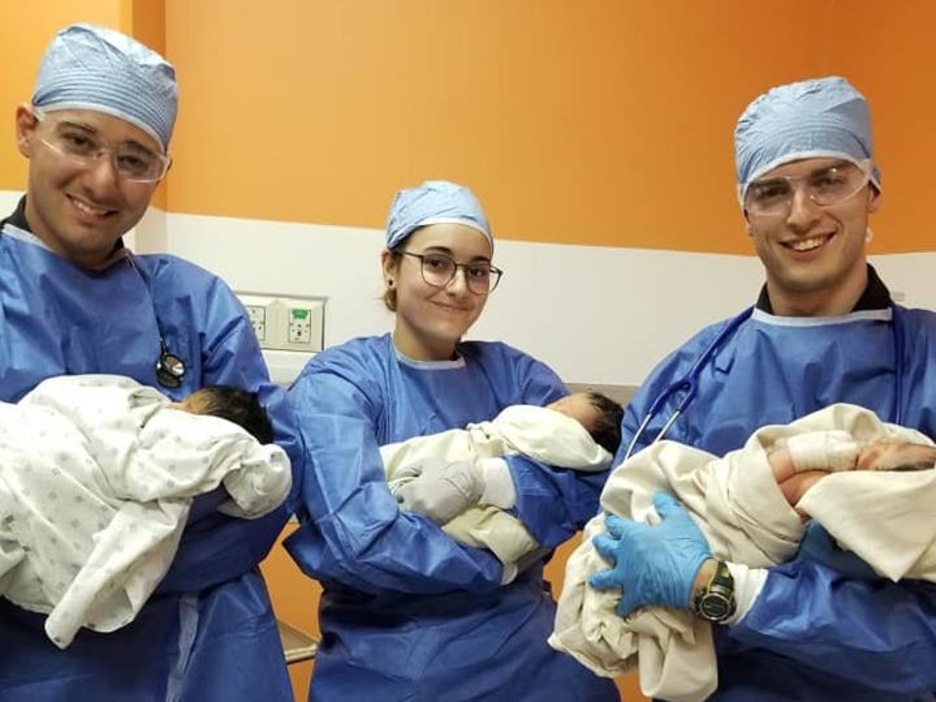 Trois étudiants québécois tenant chacun un bébé Trois étudiants québécois tenant chacun un bébé