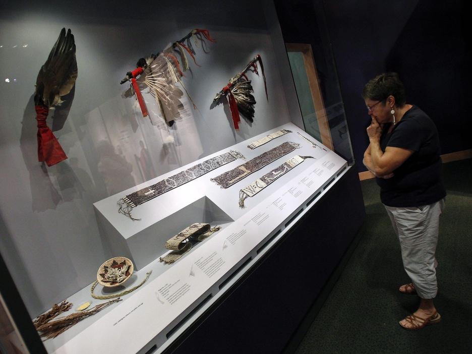 IMAGE DISTRIBUTED FOR THE SMITHSONIAN'S NATIONAL MUSEUM OF THE AMERICAN INDIAN - A visitor views Wampum belts, fans and other diplomatic tools of the Treaty process at the Smithsonian Institutions National Museum of the American Indians latest exhibition, Nation to Nation: Treaties Between the United States and American Indian Nations, on Tuesday, Sept. 16, 2014 in Washington. The exhibition opens to the public at the National Museum of the American Indian on Sunday, Sept. 21, 2014. (Paul Mor IMAGE DISTRIBUTED FOR THE SMITHSONIAN'S NATIONAL MUSEUM OF THE AMERICAN INDIAN - A visitor views Wampum belts, fans and other diplomatic tools of the Treaty process at the Smithsonian Institutions National Museum of the American Indians latest exhibition, Nation to Nation: Treaties Between the United States and American Indian Nations, on Tuesday, Sept. 16, 2014 in Washington. The exhibition opens to the public at the National Museum of the American Indian on Sunday, Sept. 21, 2014. (Paul Mor