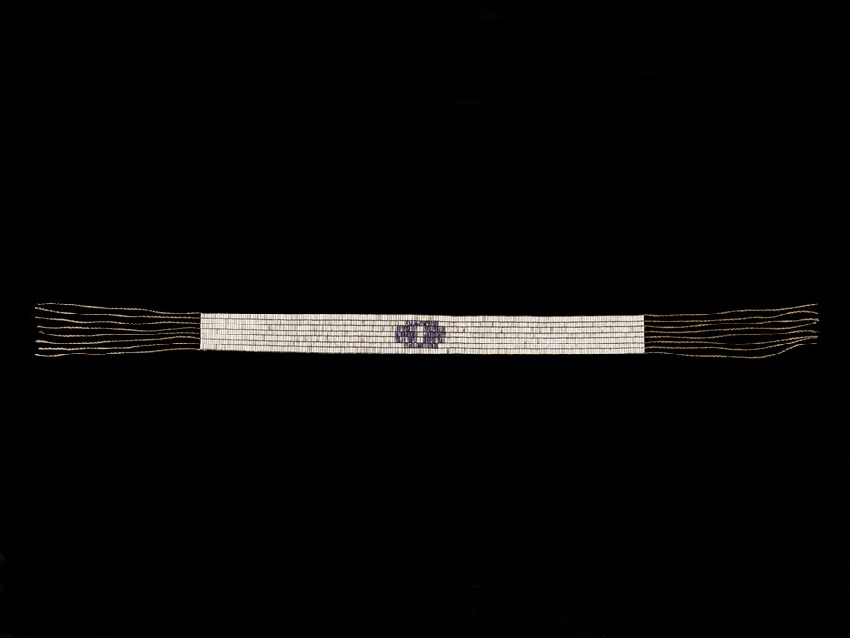 La ceinture est fabriquée en perles tubulaires de couleurs mauve et blanche. La ceinture est fabriquée en perles tubulaires de couleurs mauve et blanche.