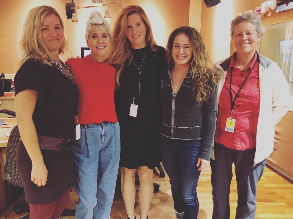 Photo de cinq femmes qui posent debout dans un studio de radio. Photo de cinq femmes qui posent debout dans un studio de radio.