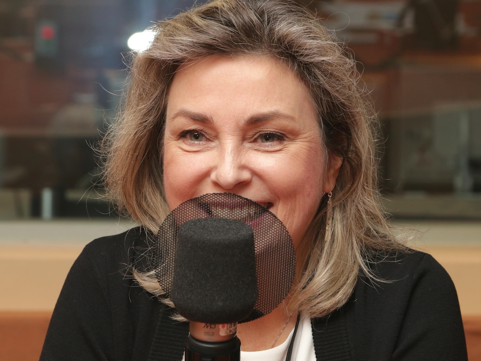 Photo de Monika Ille devant un micro de radio. Photo de Monika Ille devant un micro de radio.