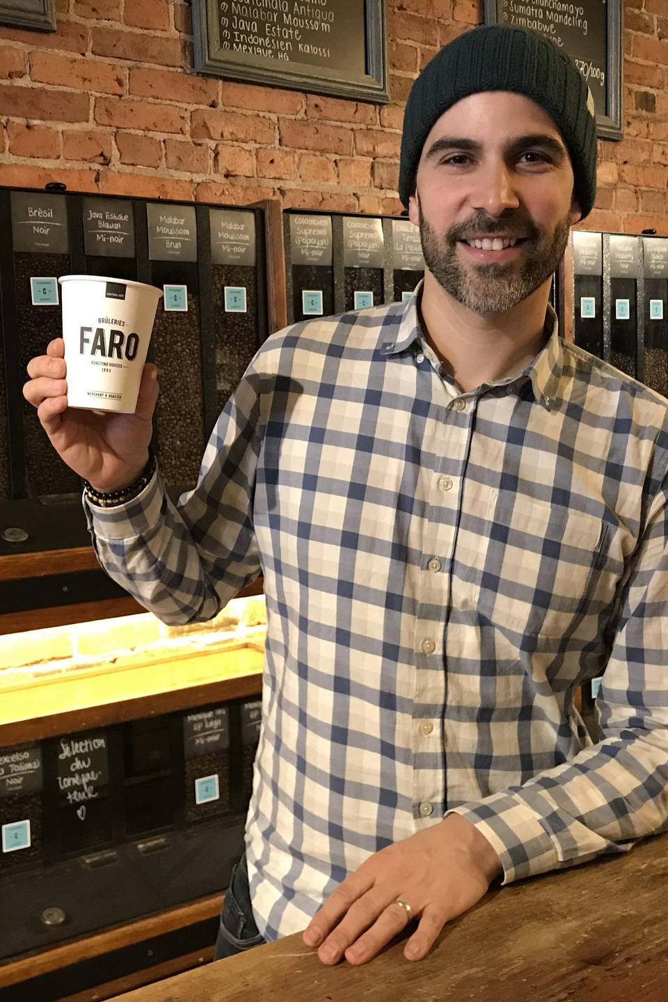 Maxime Fabi sourit à la caméra en tenant un gobelet de café dans ses mains Maxime Fabi sourit à la caméra en tenant un gobelet de café dans ses mains