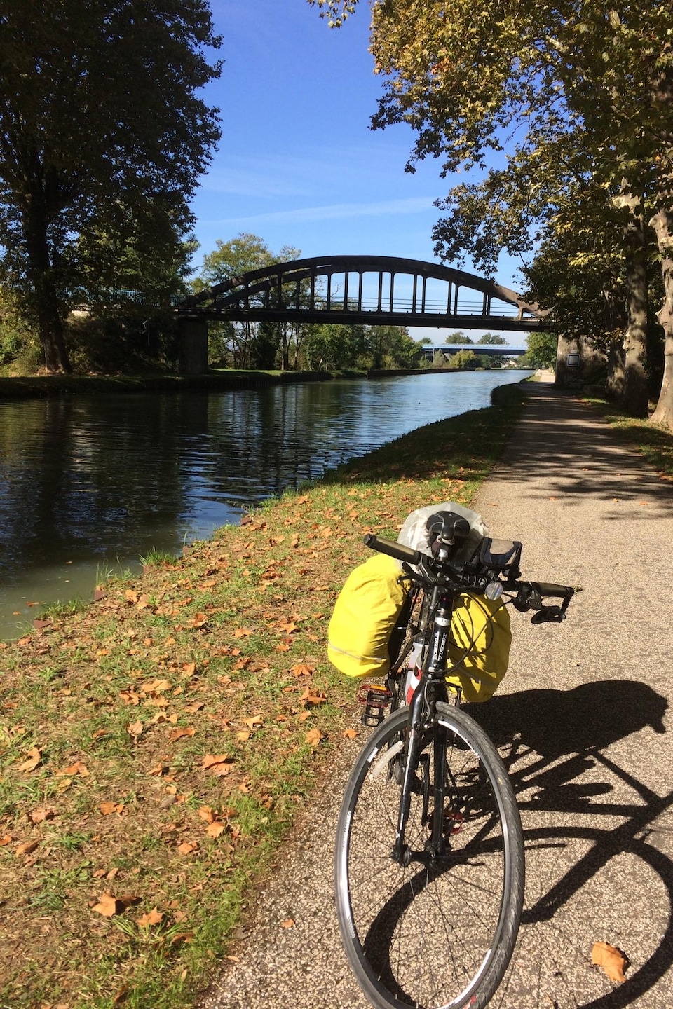 Un vélo est stationné tout juste à côté d'un canal, surplombé par un pont. Un vélo est stationné tout juste à côté d'un canal, surplombé par un pont.