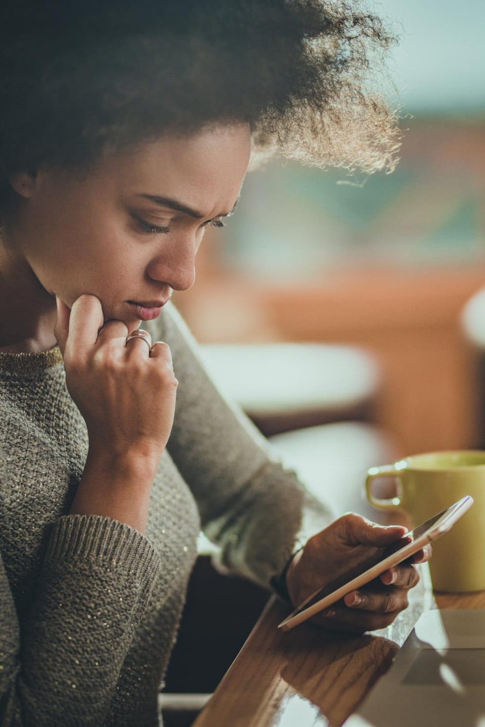Une jeune femme utilise un téléphone intelligent et un ordinateur portable. Une jeune femme utilise un téléphone intelligent et un ordinateur portable.