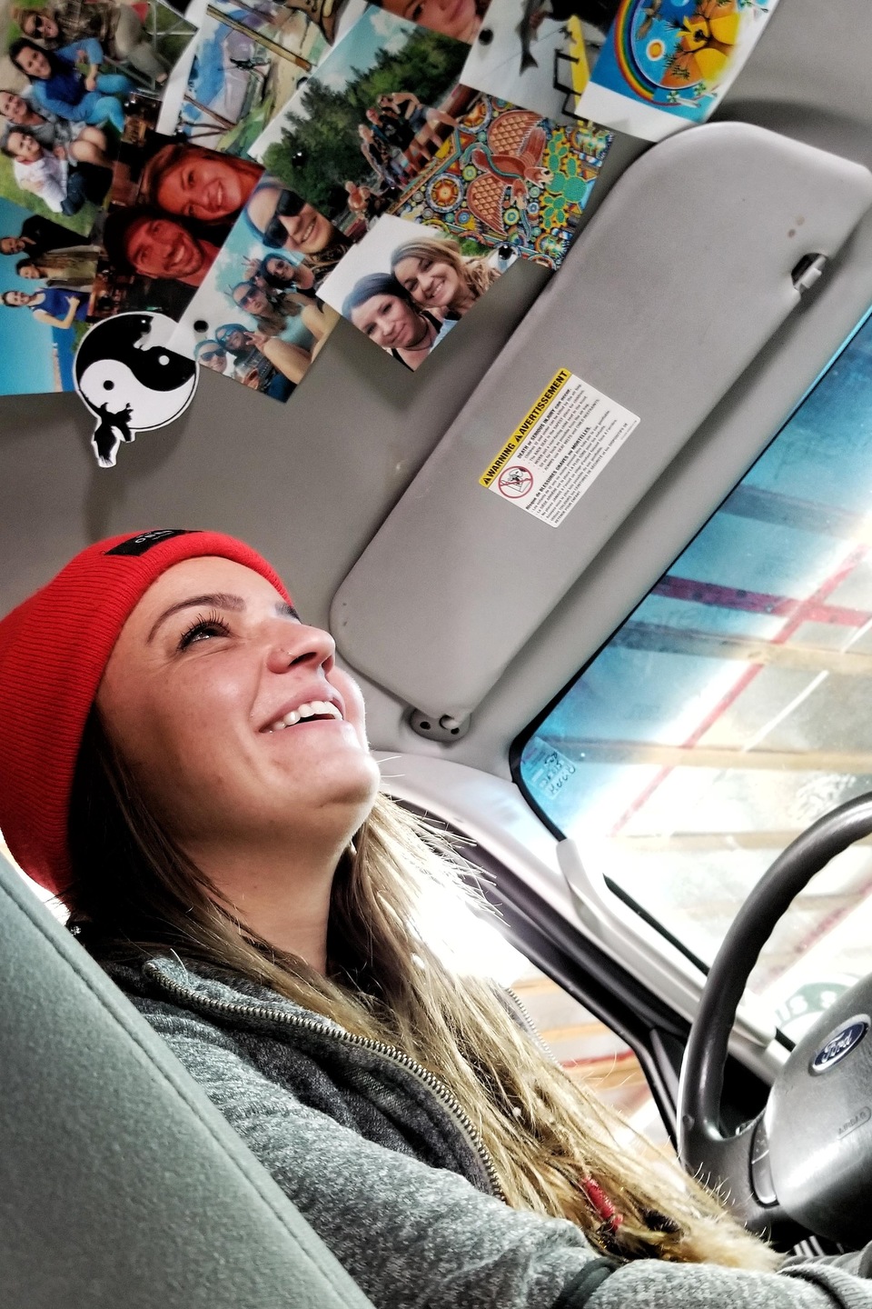 Stéphanie Tremblay dans sa fourgonnette avec des photos de ses proches au-dessus de la tête Stéphanie Tremblay dans sa fourgonnette avec des photos de ses proches au-dessus de la tête