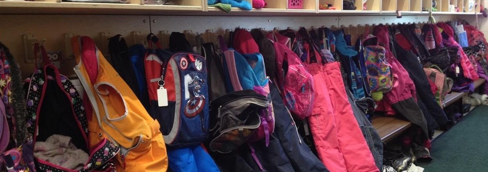 Image de manteaux d'enfants et de sacs d'école sur crochet et sous bacs de rangement. Image de manteaux d'enfants et de sacs d'école sur crochet et sous bacs de rangement.