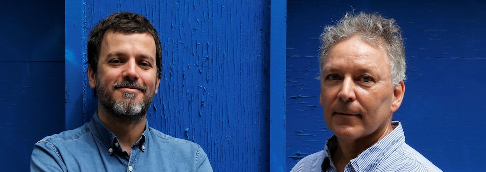 Deux hommes sont devant une porte de garage bleue. Deux hommes sont devant une porte de garage bleue.