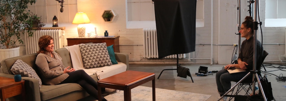 Dans un studio, entourée d'équipement technique, elle est assise dans un canapé et elle discute avec la réalisatrice.